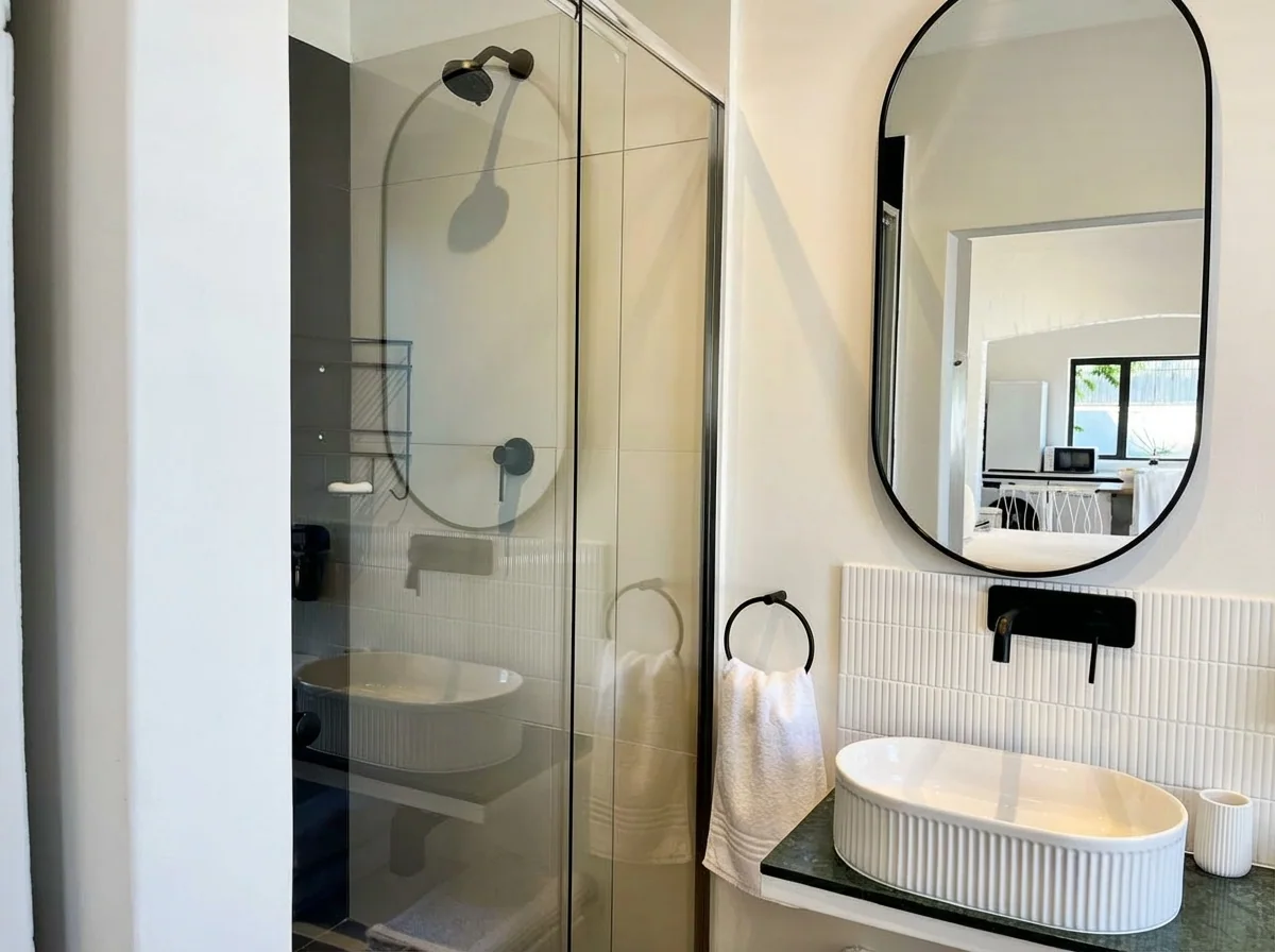 Ibis Cottage bathroom — walk-in shower, arched mirror and vessel basin