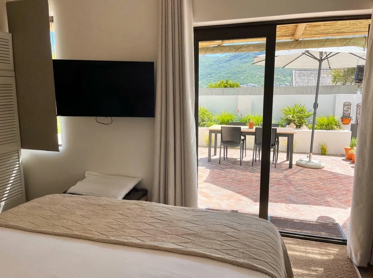 Ibis Cottage bedroom with patio view and wall-mounted TV
