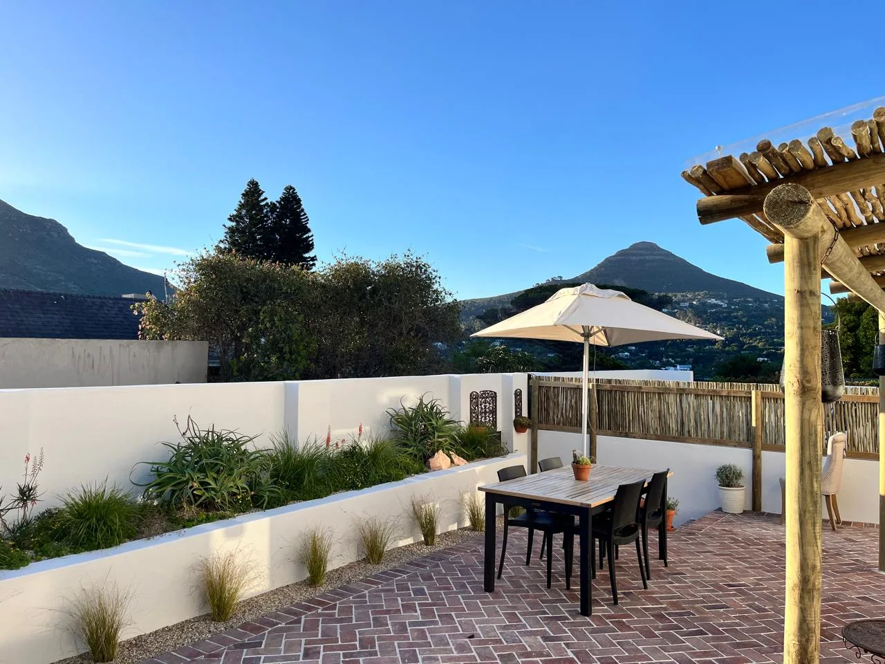 Ibis Cottage patio with umbrella dining and a Hout Bay mountain backdrop
